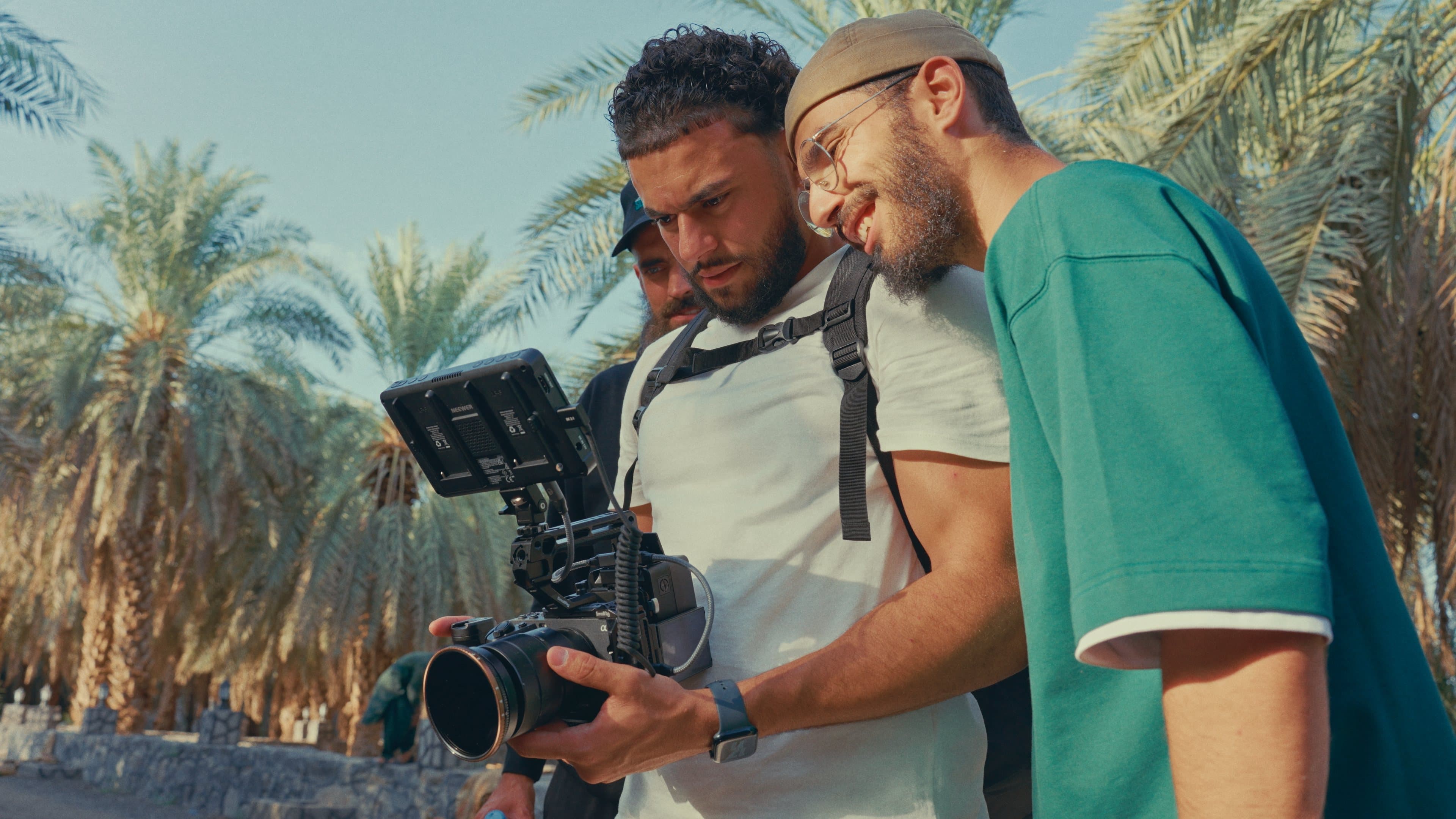 Sacred Chronicles filmmakers reviewing footage among palm trees